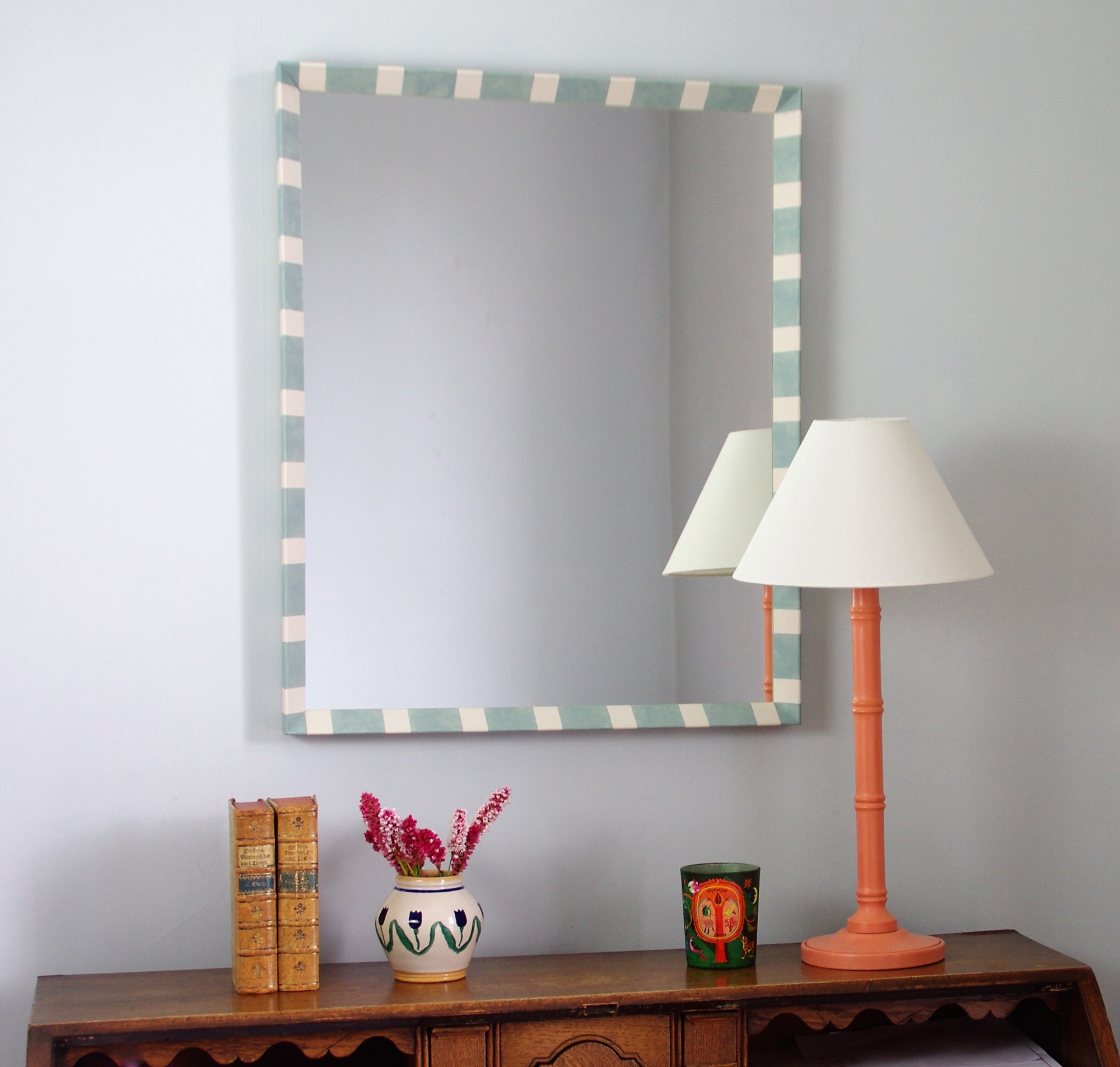 striped rectangular mirror styled over a bureau